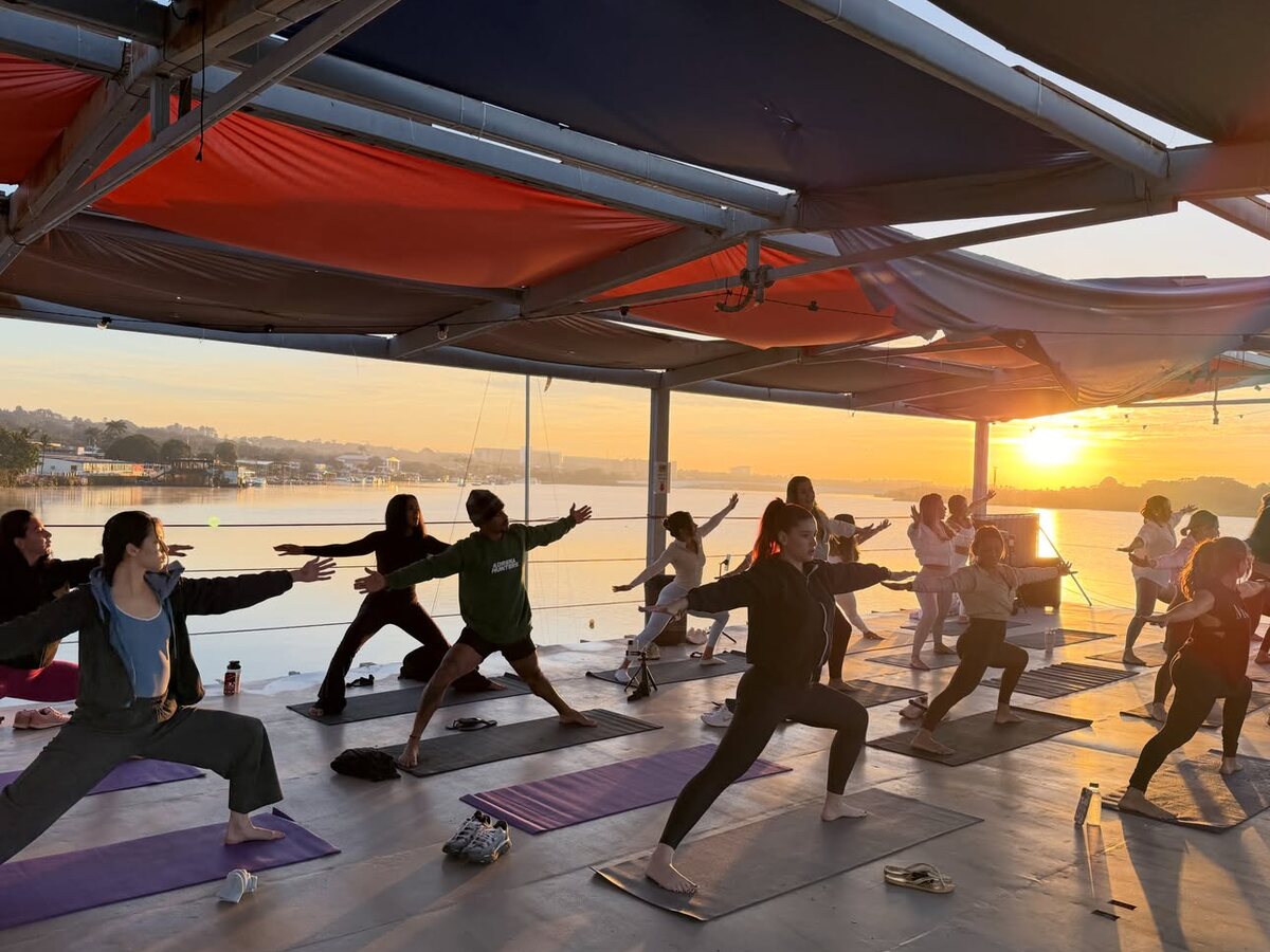Yoga ao nascer do sol sob tendas coloridas